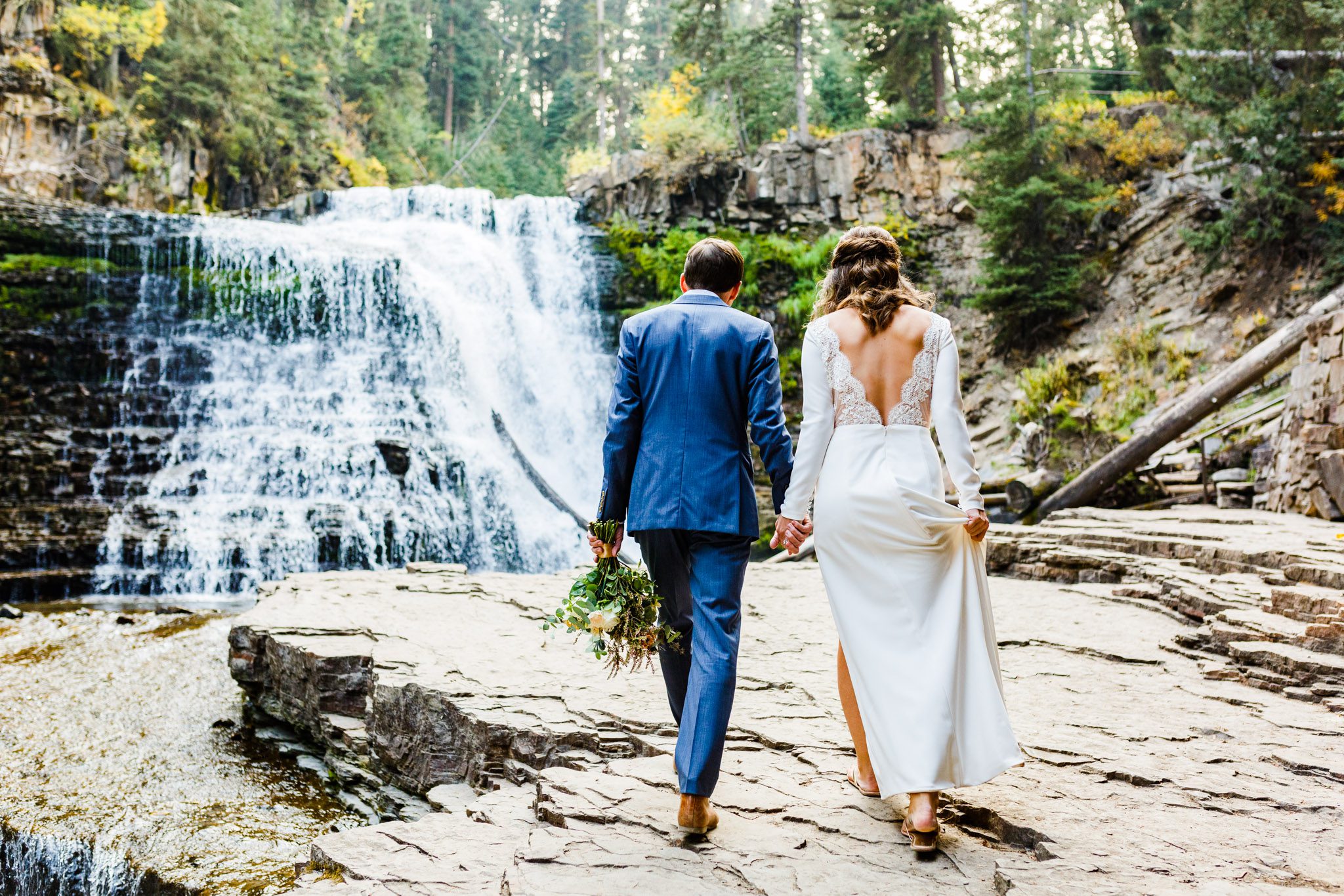 couple walking by waterfall wedding in spring season