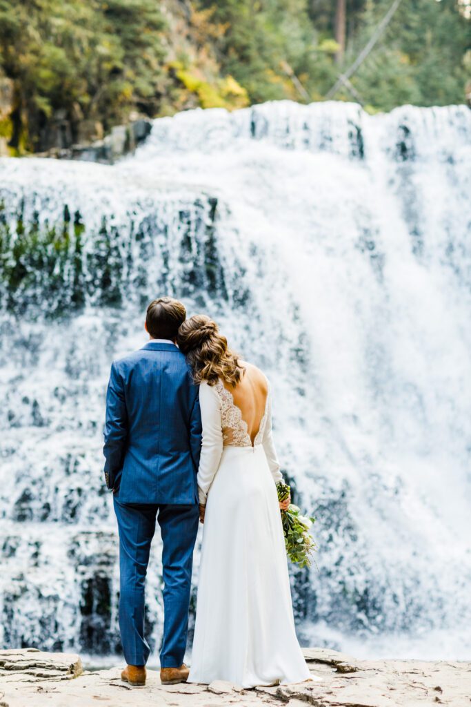 couple in front of waterfall, elope in Montana