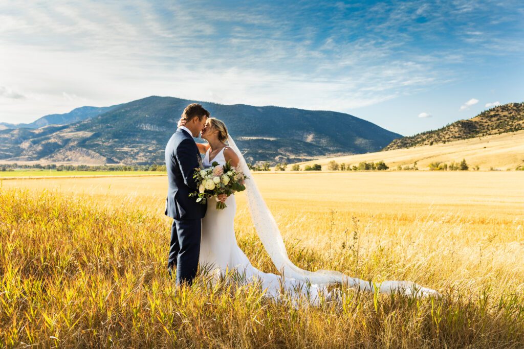 bride and groom in a golden field in paradise valley, mt